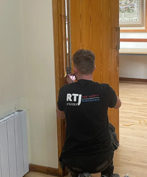 Fire Door Maintenance RTJ employee screwing door hinges