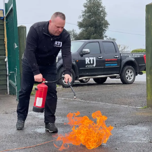 RTJ of Sussex Man putting out fire with fire extinguisher
