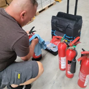 Fire Extinguisher Install & Maintenance Roy of RTJ servicing several fire extinguishers