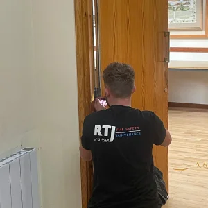 Fire Door Maintenance RTJ employee performing maintenance on a fire door