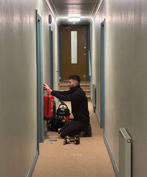 Where Fire Stopping is Needed RTJ employee installing a fire extinguisher to a wall